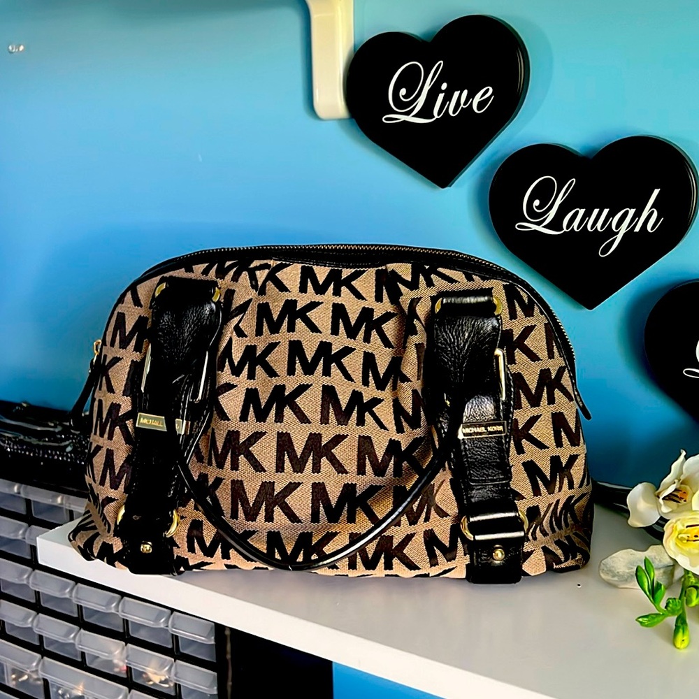 This is Michael Kors handbag that is tope and black with gold accents.